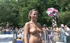 A bunch of people look on as a nude girl struts on a stage at a show - movie 1 - 7