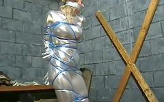 Blonde with big boobs in form-fitting silver jumpsuit is tied up in bondage - movie 12 - 4