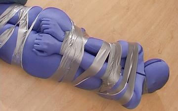Herunterladen Completely encased female is bound with duct tape in bdsm bondage scene