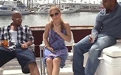 A blonde girl on a boat gets laid by two black men at the same time join background